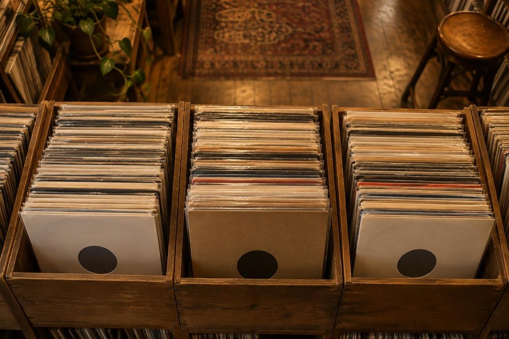 Cajas de madera llenas de discos de vinilo en fundas lisas en una tienda de discos